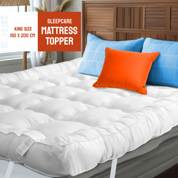 An ultra soft white mattress topper on a bed with colorful pillows